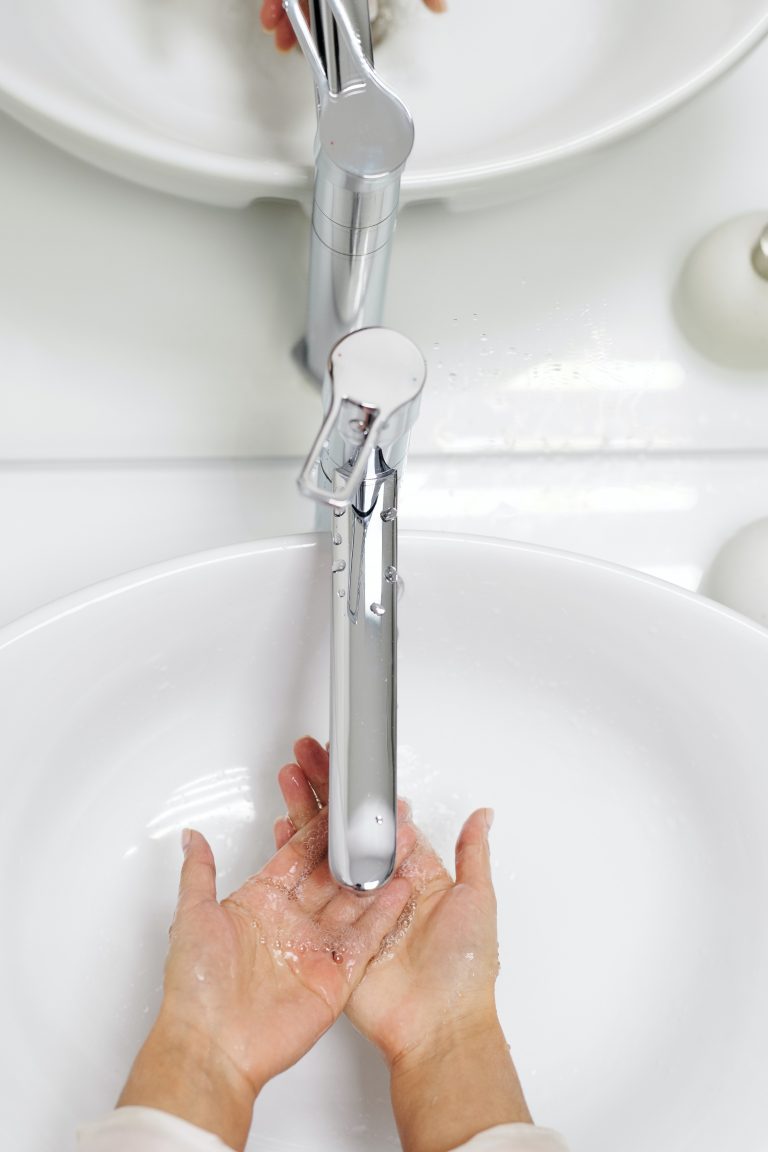 Une personne se lave les mains aux lavabo