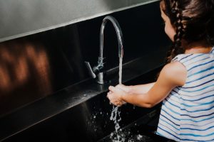 Une fillette se lave les mains avec de l'eau chauffée par une pompe à chaleur