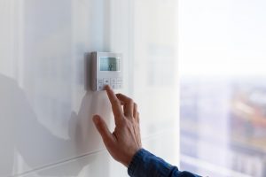 Un homme configure son thermostat